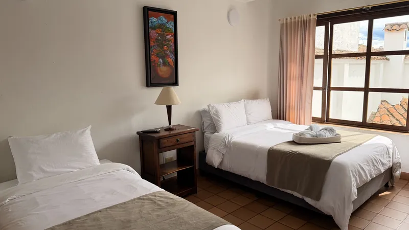 Habitación San Valentín con cama doble, cama sencilla, mesa de noche y ventana grande de madera